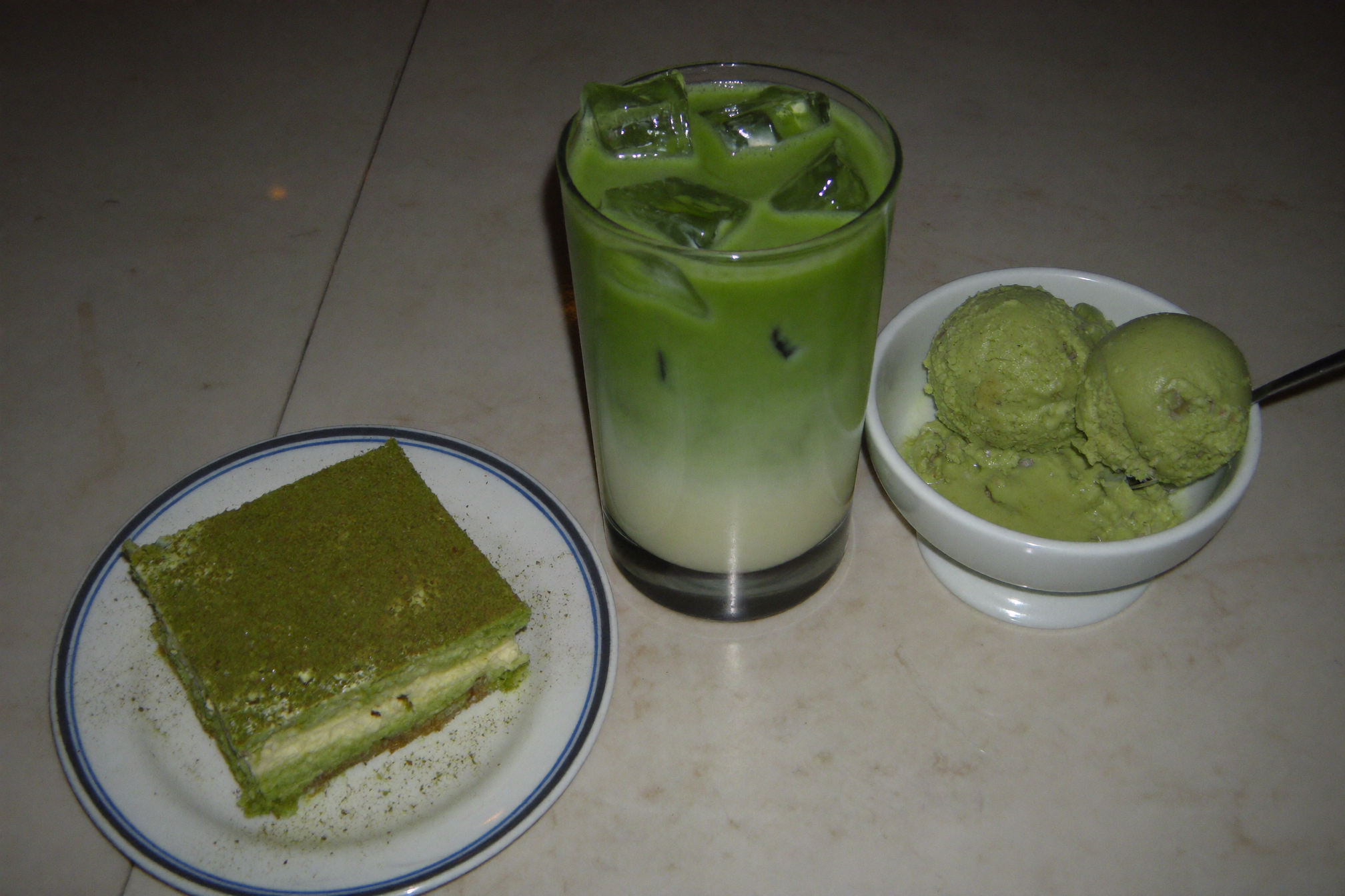 Matcha tiramisu, iced matcha latte and matcha ice cream on a table