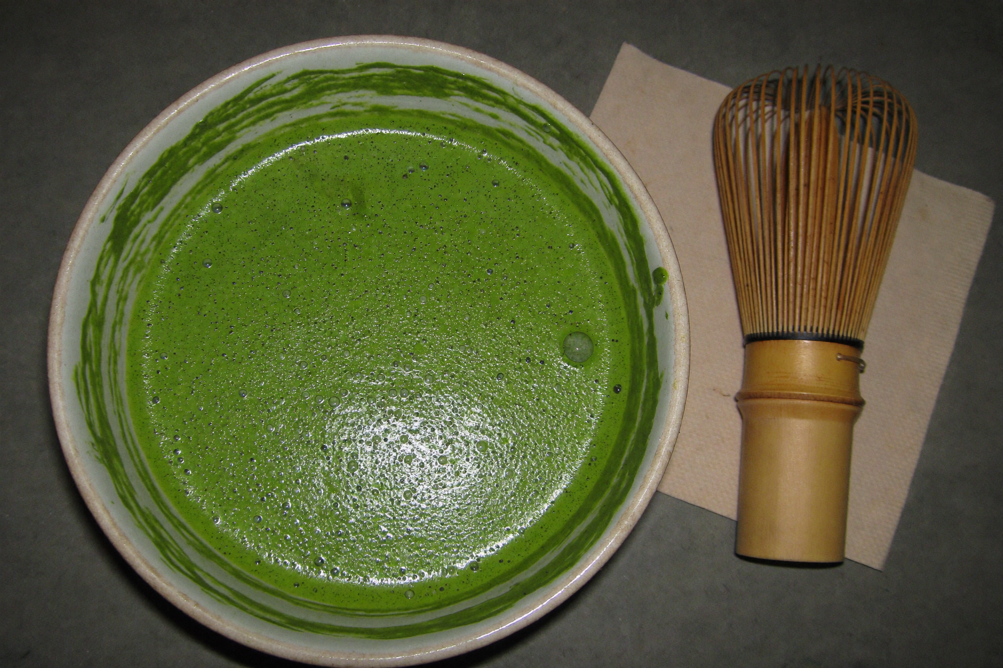 Bowl of freshly whisked matcha with a bamboo chasen, the standard 2 gram serving